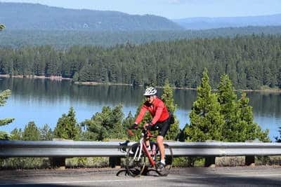 Bicylist oon Johnson Grade with Lake Almanor in background