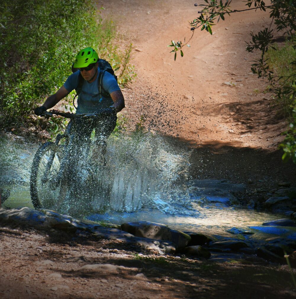mountain biker splashing through water
