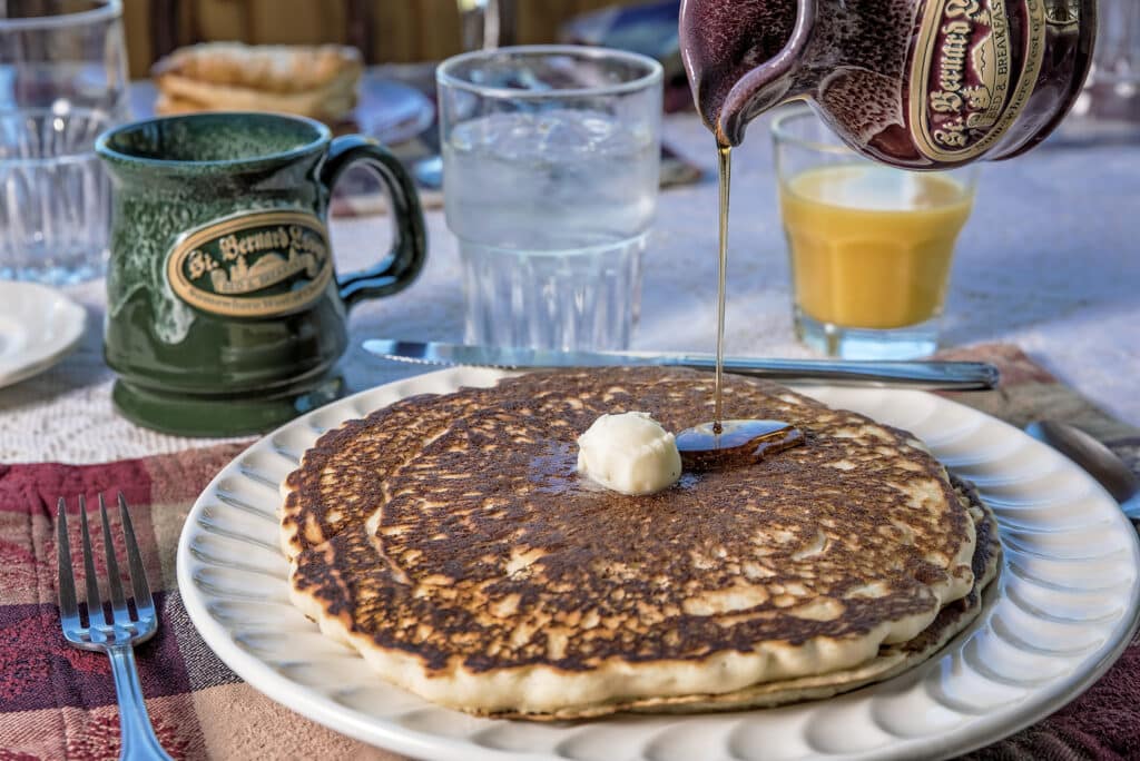 Pancake, coffee cup, and orange juice during breakfast service at St. Bernard Lodge, a B&B in Northern CA near national parks in California.