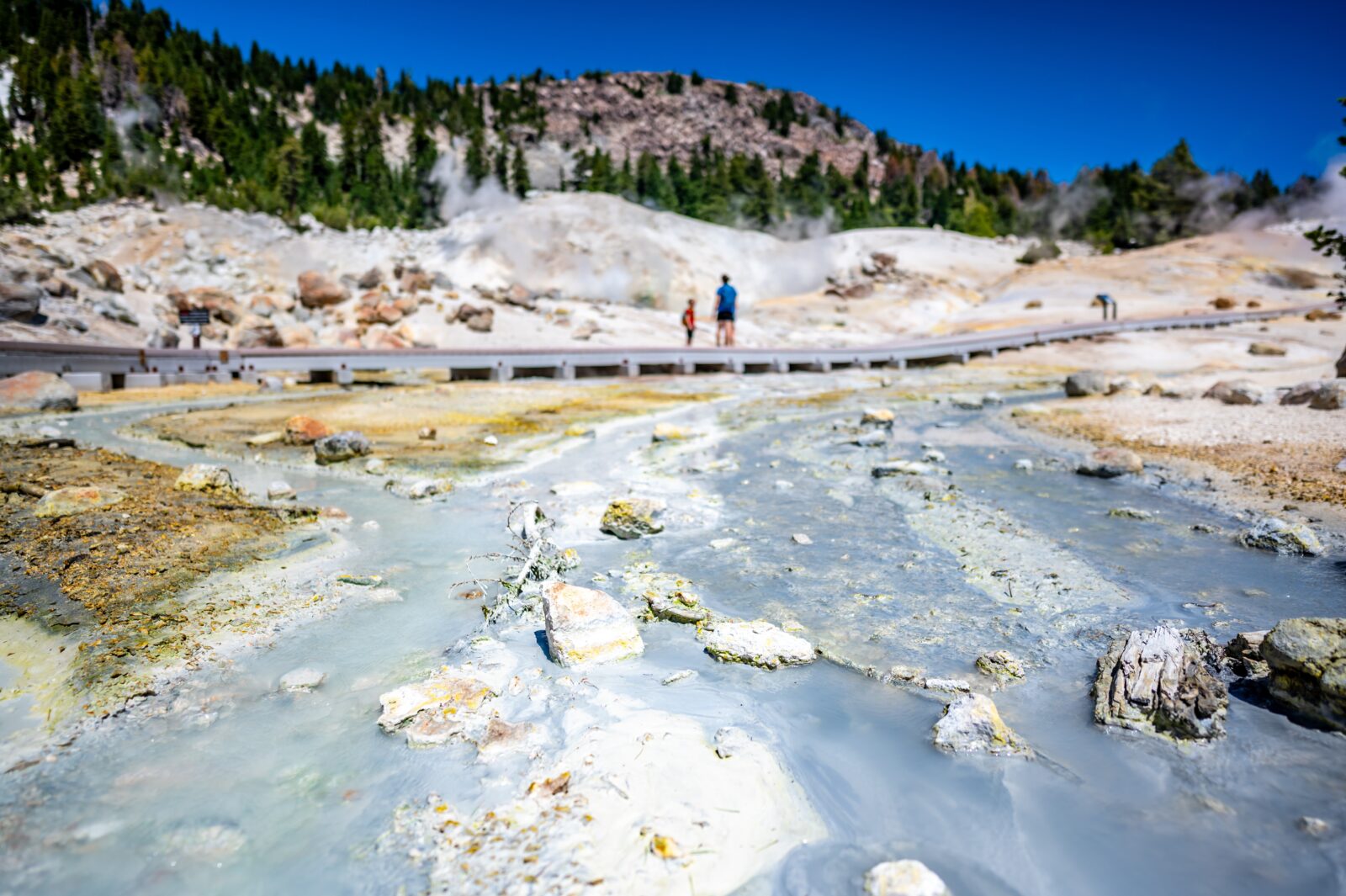 Bumpass Hell with hikers on boardwalks. This is one of the most popular Lassen Volcanic National Park trails.